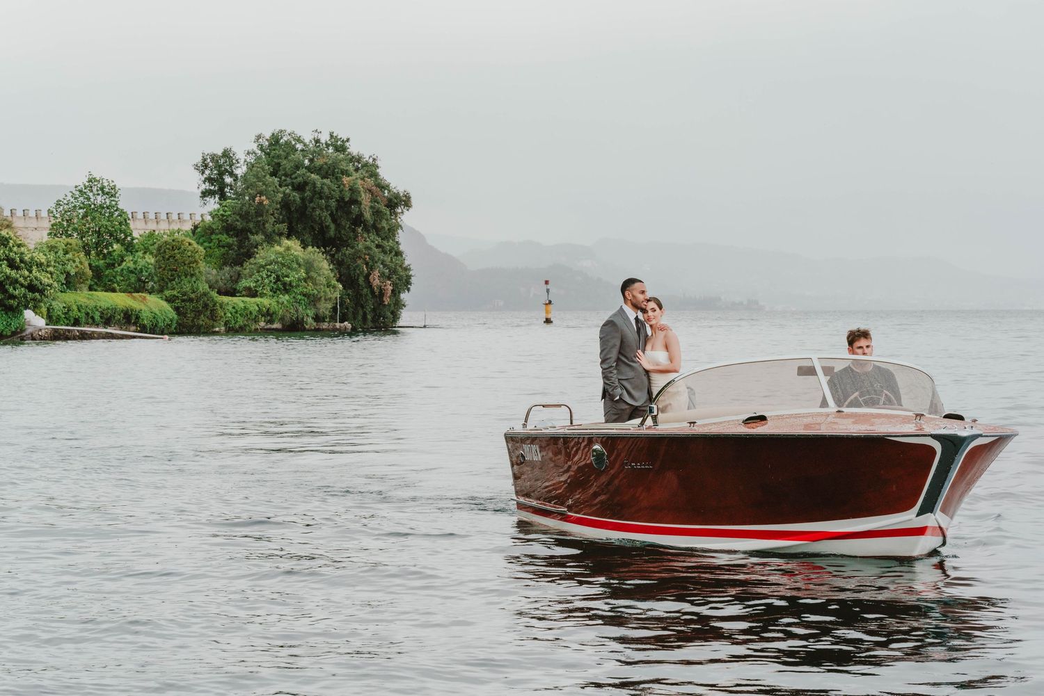 Italy Wedding Photographer Lake Garda couple on a boat hugging each other Cotswolds Gloucestershire