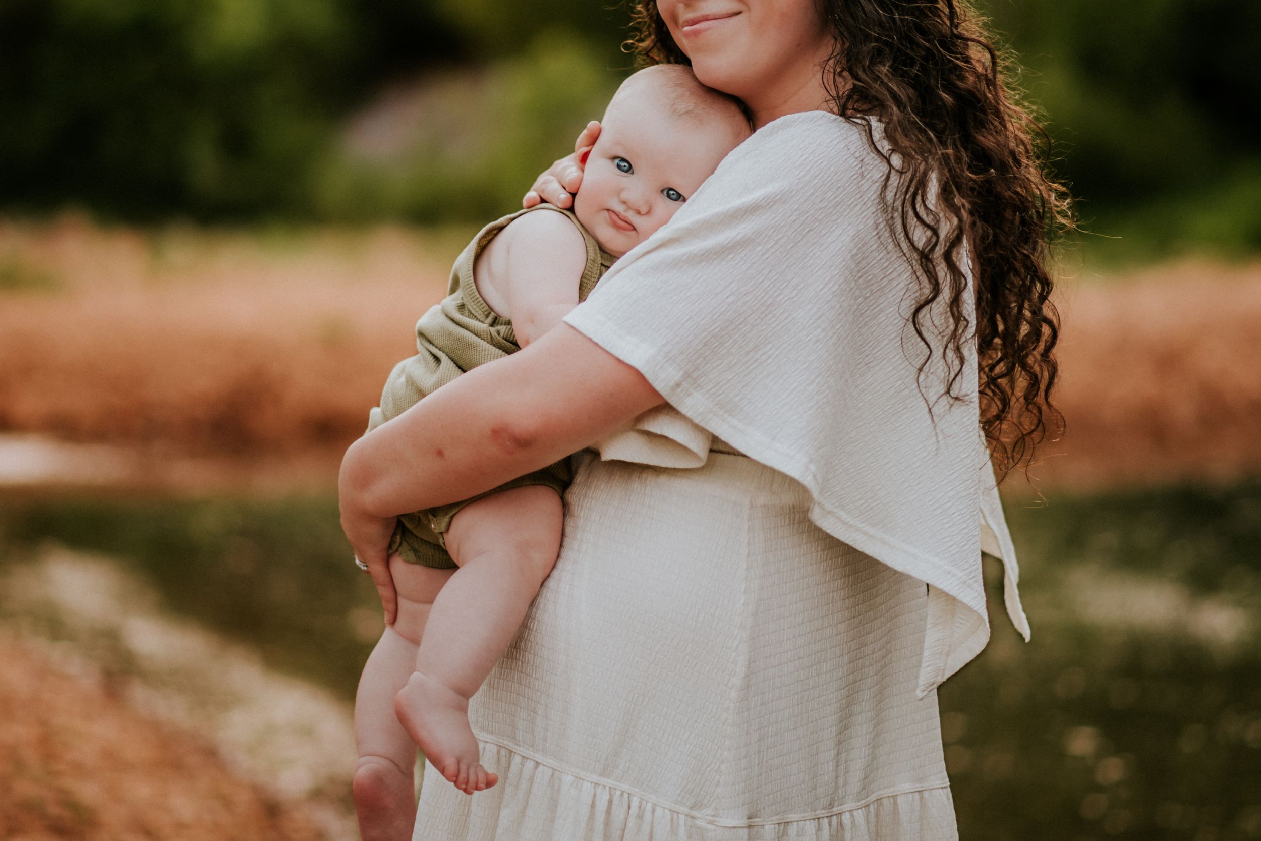 A sweet moment of a mother holding her baby son as he stares deeply at the photographer's camera at Fort Campbell, Tennessee.