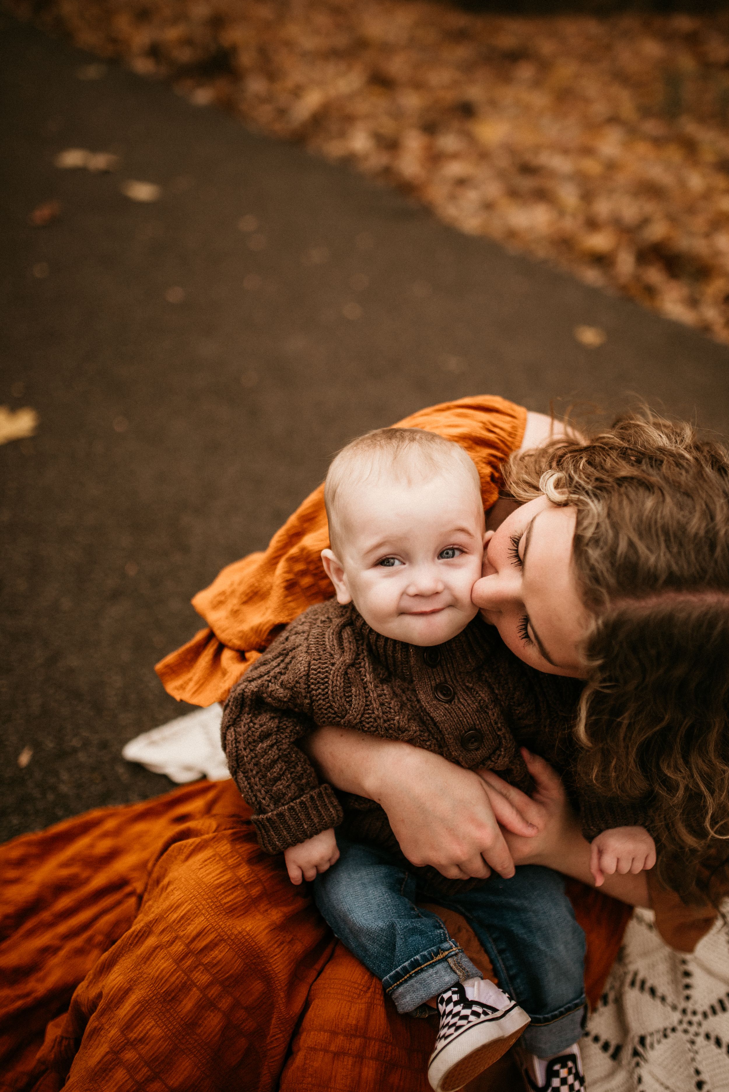 Motherhood photo of mother kissing her son in the fall foliage in Clarksville, Tennessee.