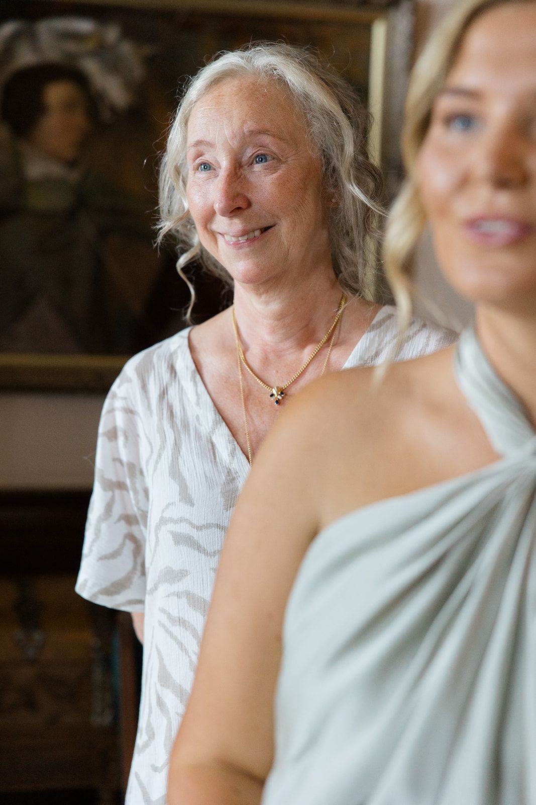 Two people in conversation share a candid moment while wearing white and mint colored attire.