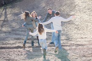 Drie jonge kinderen rennen naar hun ouders tijdens een fotoshoot door Inge Muller Fotografie, bij de diepe kuil in Hellendoorn