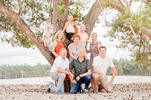 Familiefotoshoot voor een naaldboom. In zomerskleding op de zandverstuiving bij Ommen