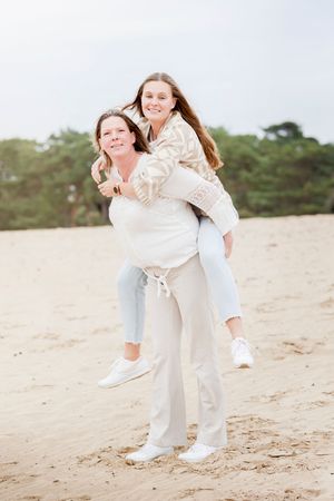 Twee verliefde vrouwen bij elkaar op de rug tijdens hun gezinsshoot door Inge Muller Fotografie