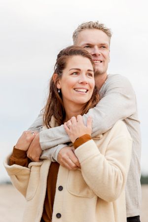 Man staand achter zijn vrouw en houd haar vast over de schouders, beide opzij kijkend tijdens een fotoshoot op de Sahara Ommen