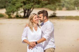 Verliefd koppel tijdens loveshoot, gemaakt door Inge Muller. Zomers gekleed voor een fotoshoot op de zandvlakte bij Ommen