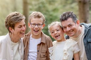 Jong gezin van vier, lachen en kietelen elkaar