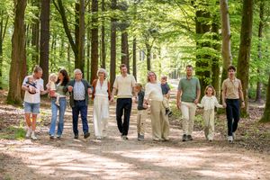 grote familie op een rij lopend door een groen bos