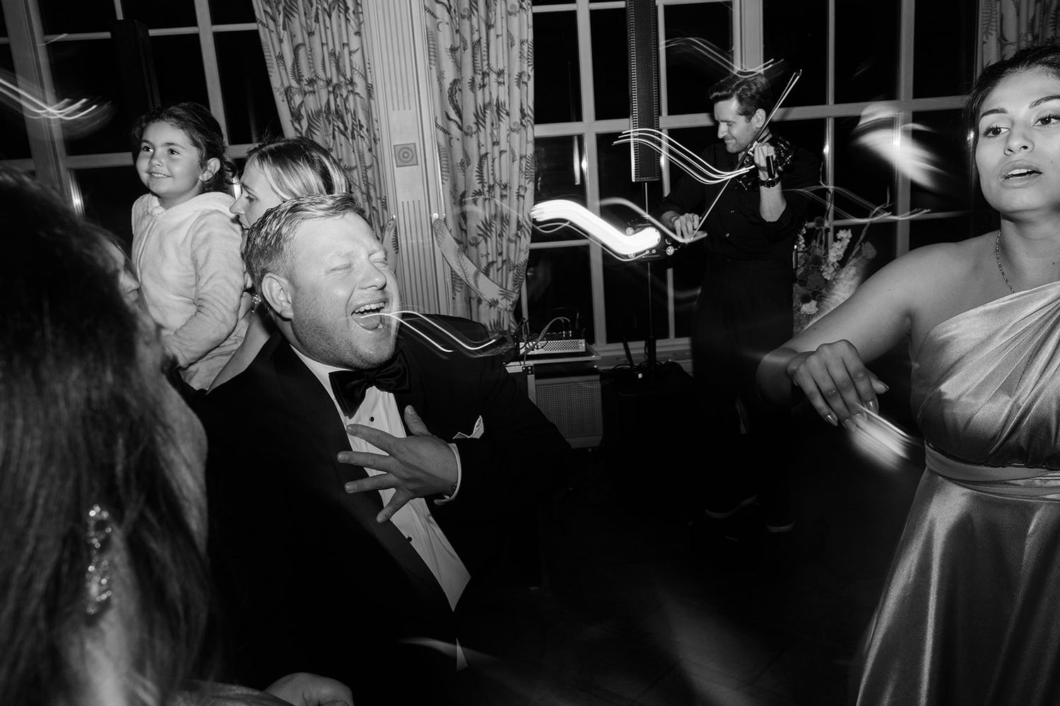 People dancing and celebrating at a lively party in black and white photography.