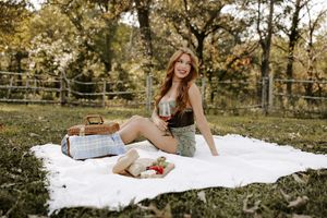 Cozy autumn picnic setting with white blanket and vintage accessories in a park.
