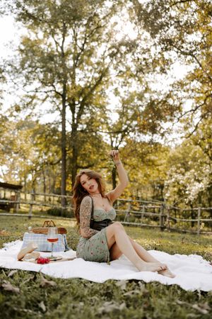Cozy fall picnic setup with white blanket and rustic accessories in park.