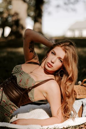 Artistic outdoor boudoir photography with dramatic lighting and natural backdrop.