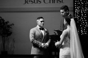 A couple shares an intimate moment during their first look wedding reveal with twinkling lights in the background.