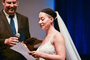 Wedding ceremony in progress with blue lighting and decorative backdrop.