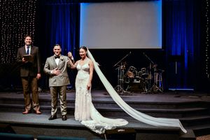 Wedding ceremony moments captured against a backdrop of sparkling lights and blue stage curtains.