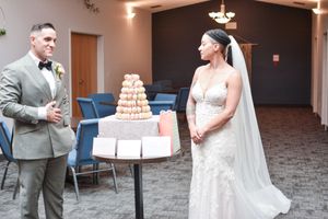 Wedding reception setup showing a couple with a macaron tower dessert display.