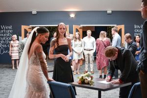 Wedding reception venue with dark blue walls and guests mingling in casual atmosphere.