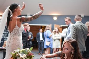 A celebratory moment at an indoor wedding reception with guests in the background.