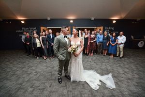 Guests dancing and celebrating at a wedding reception on a dark carpeted floor.