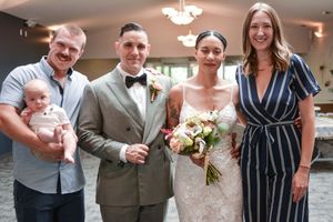 Wedding guests enjoying outdoor reception with champagne toasts and laughter at elegant garden venue.