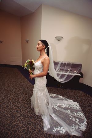 A stunning wedding dress with a flowing lace train displayed in an elegant indoor setting.