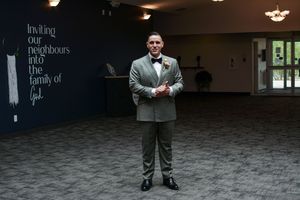 Wedding venue interior with dark walls featuring elegant text designs and lighting.
