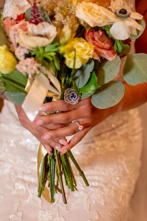 Close-up details of floral wedding bouquets with peach and pink blooms against a light background.