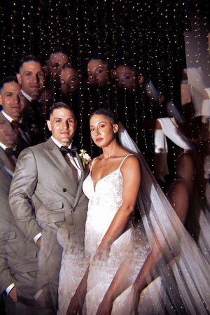 A wedding celebration with sparkly lights and formal attire against a dark backdrop.