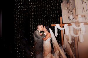 Silhouetted couple sharing a romantic kiss against a backdrop of twinkling fairy lights.
