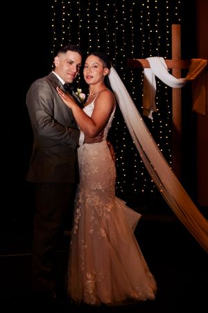 Romantic dance moment with twinkle light backdrop at wedding reception.