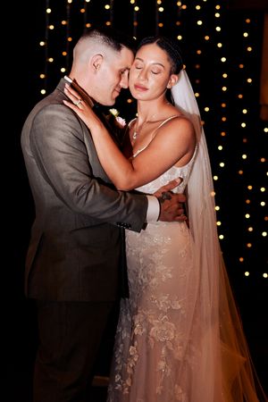 Romantic first dance with twinkle lights creating magical ambiance.