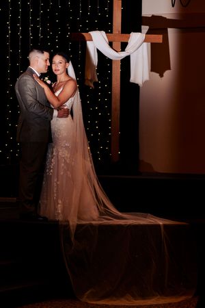 A romantic wedding moment captured with twinkling fairy lights creating a magical backdrop.