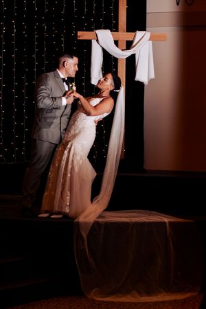 Couple dancing at wedding reception with string light wall decoration.