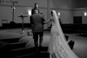 A romantic moment captured in black and white as newlyweds share their first dance in a reception hall.