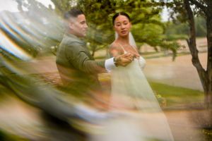 Wedding photography captured through glass with a dreamy, artistic blur effect outdoors.