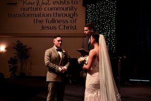 Wedding ceremony setup with twinkle lights and text display in a church setting.