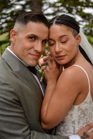An intimate wedding portrait showing a tender embrace outdoors.