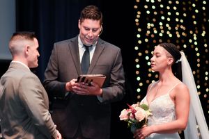 A wedding ceremony scene with string lights in the background and a couple exchanging vows at the altar.