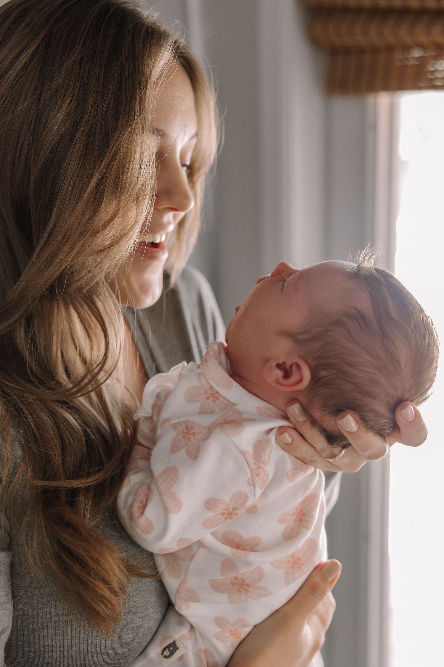 Gentle moments between parent and infant in soft natural window light.