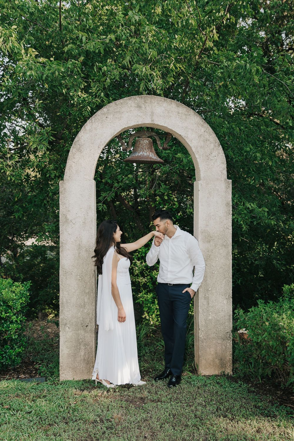 A series of wedding photos showing a couple through decorative stone archways in a garden setting.