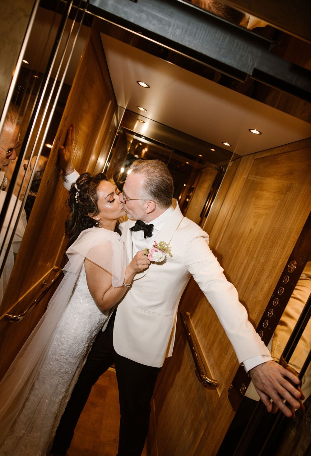 Intimate wedding moments captured in a warm-lit wooden hallway.