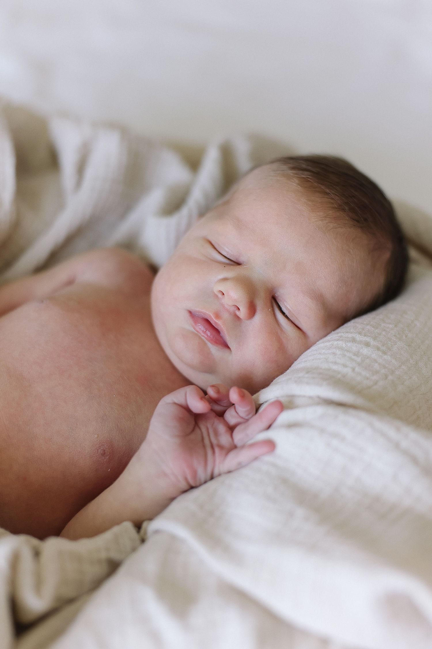 Detail shot of newborn’s tiny fingers against a neutral blanket in California