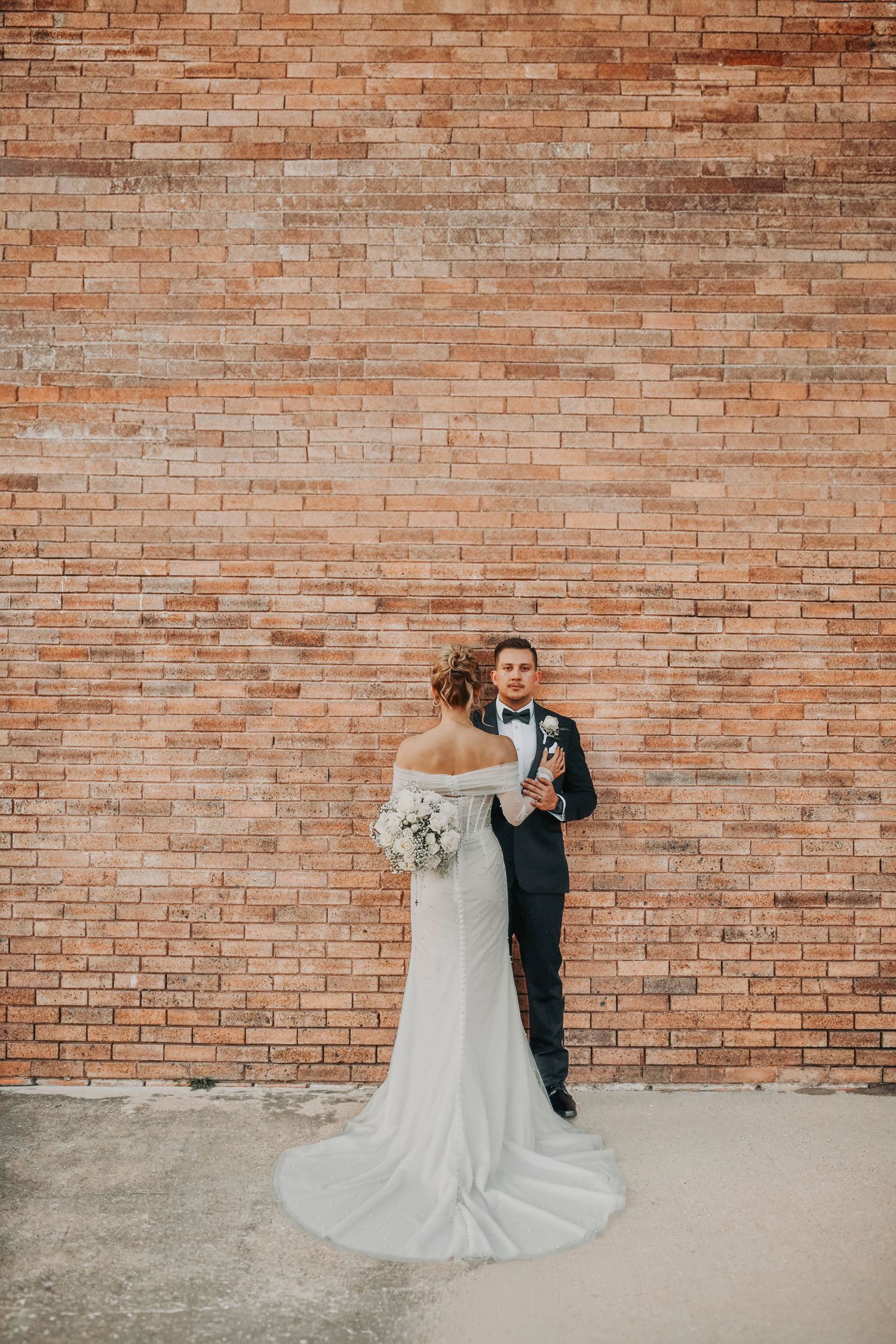 Candid moment of the couple laughing together on a Deep Ellum sidewalk during sunset, showcasing modern Dallas wedding photography