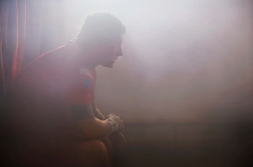Silhouette of athletes in dramatic lighting during sports action.