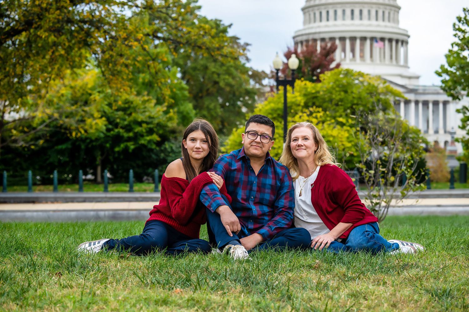 A group of people wearing coordinated red and blue outfits pose together in front of the US Capitol building.
