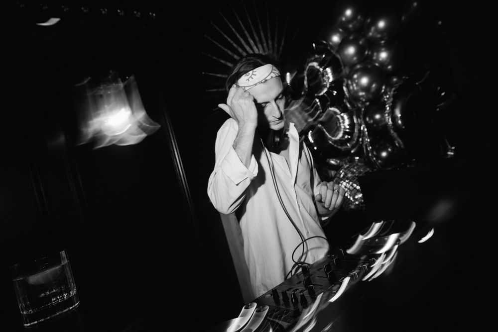 Black and white concert photography shows a musician performing with a trumpet on a dark stage.