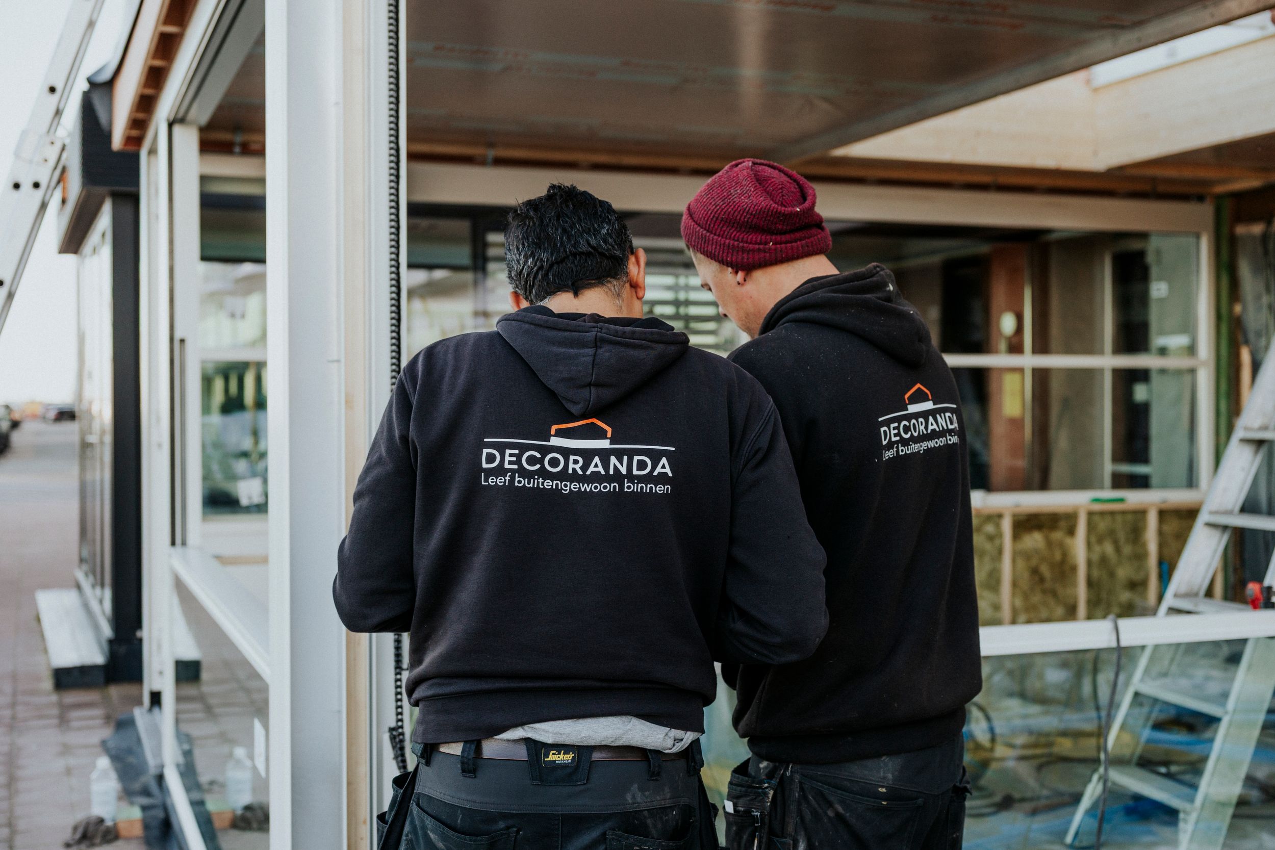 Workers in black uniforms working on a construction project indoors.