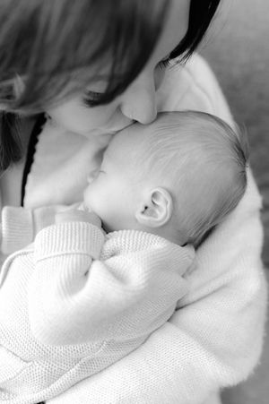A series of tender black and white photographs showing a mother kissing her sleeping baby.