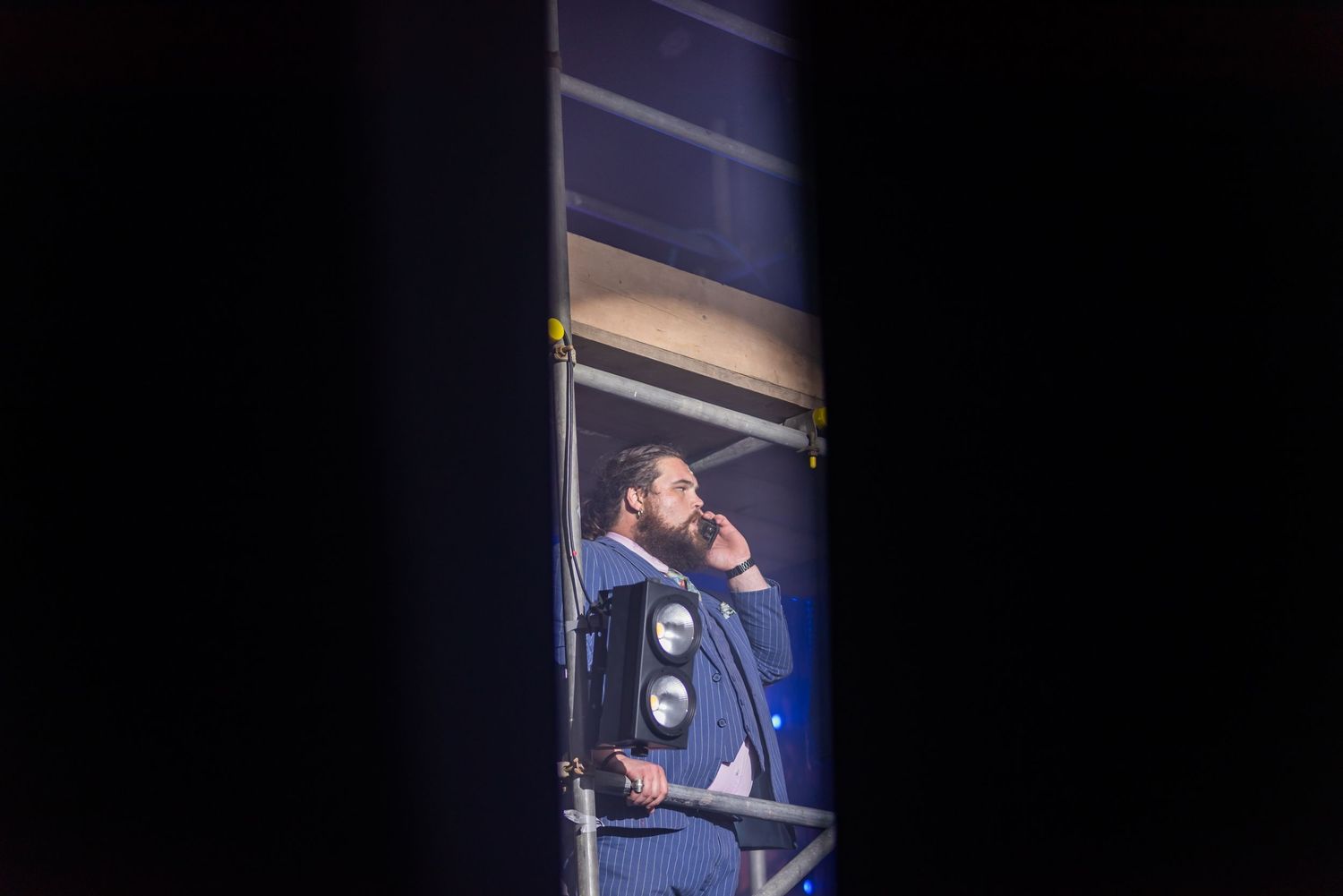 Blue-tinted stage performance with dramatic lighting and silhouettes.