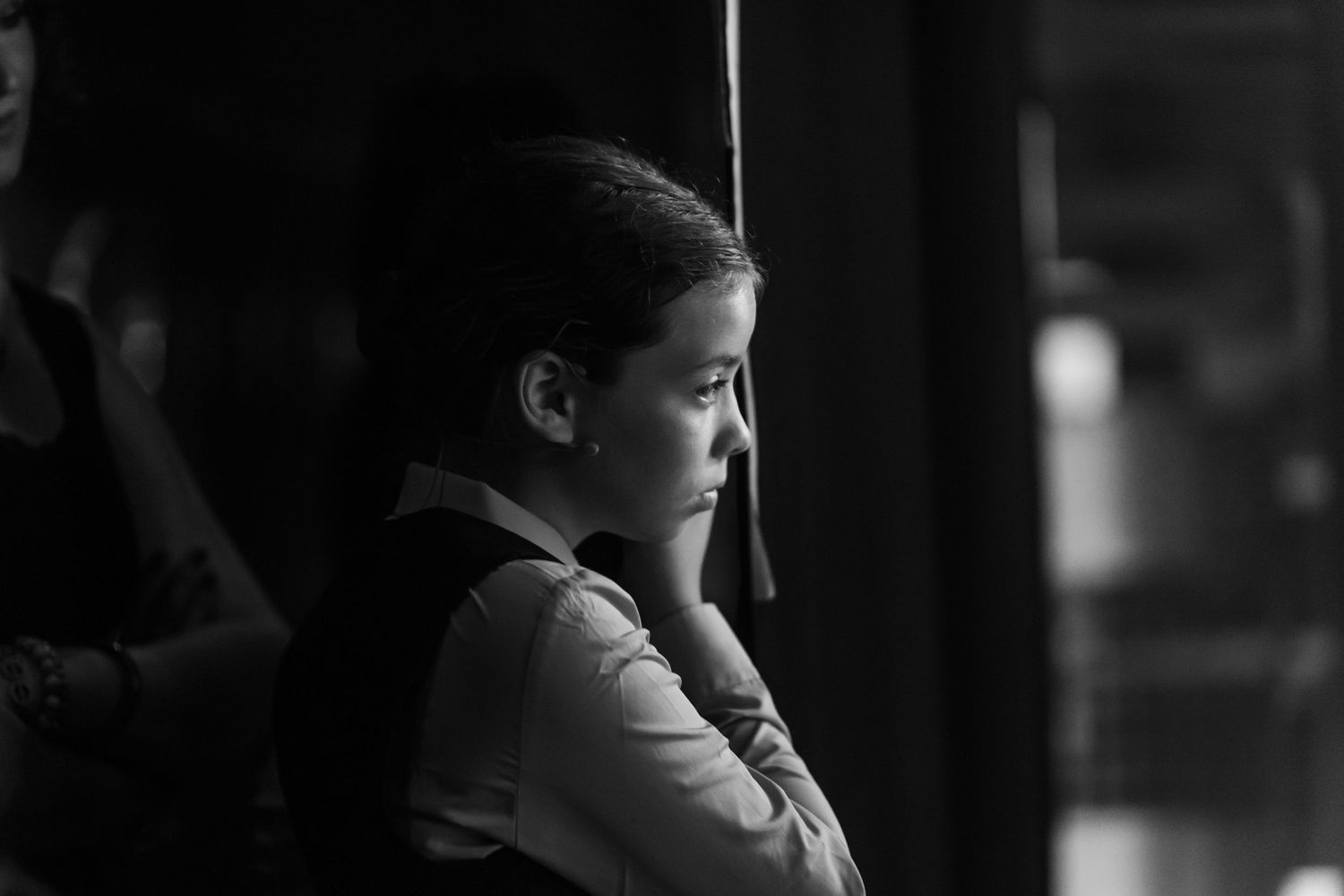 Dramatic black and white side profile portrait in moody lighting.