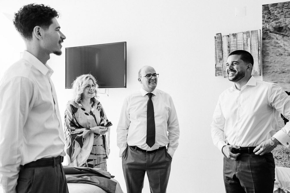A group of professionals having a casual business conversation in a modern office setting.